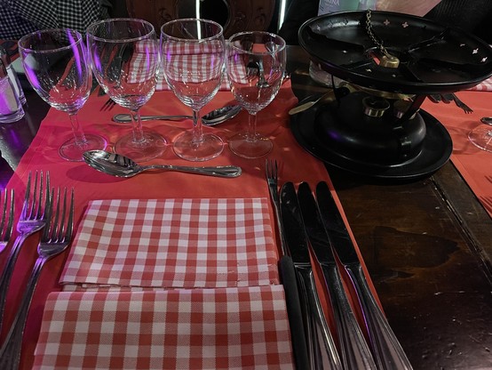 Ein gedeckter Tisch für Schweizer Fondue. Ohne Teller und Topf.