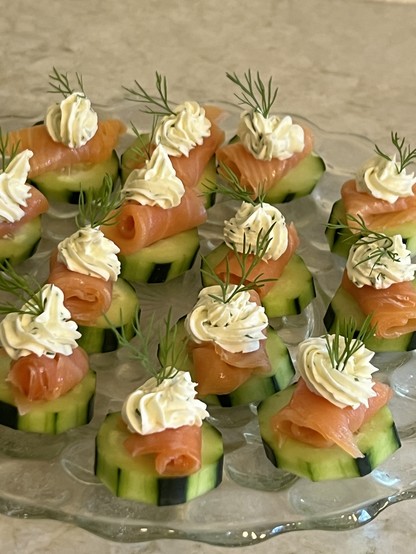 Cucumber rounds , topped with rolled lox, cream cheese and a sprig of dill