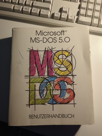 a book on a table. it's the Microsoft MS-DOS 5.0 User Manual.