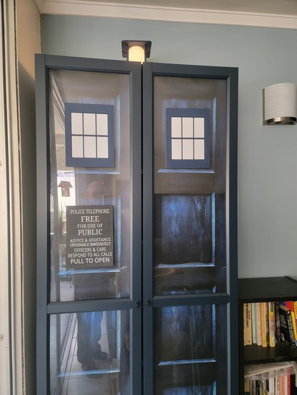 Blue Ikea bookcase with 3d printed accessories to make it look like the Tardis exterior