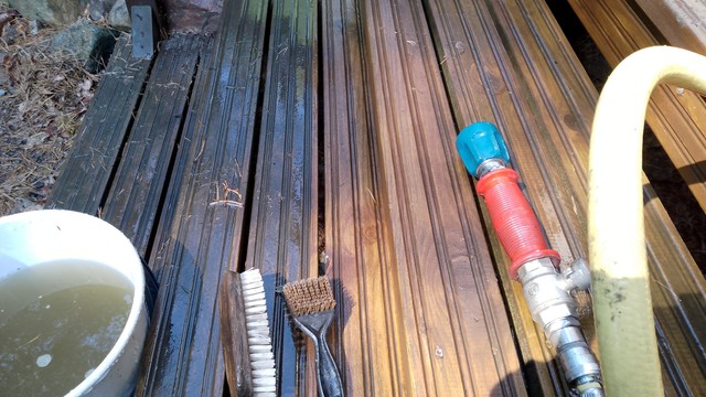 Stairs of a wooden deck being cleaned with water one board at the time.
