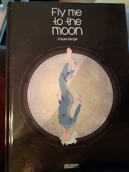 Das Cover zeigt in der Mitte eine weiblich aussehende Person kopfüber schwebend dahinter ein Mond, dessen Durchmesser ungefähr der Länge der Person entspricht. Darüber der Titel Fly me to the Moon und etwas kleiner der Name der Künstlerin, Frauke Berger.