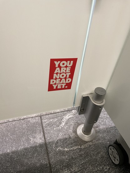 Sticker auf Toilettentür: YOU ARE NOT DEAD YET