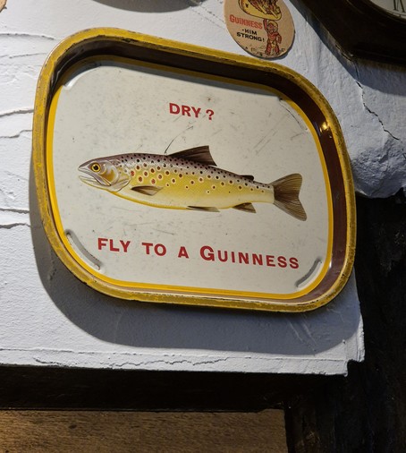 Werbeschild bzw. Tablett für Guiness. Abgebildet ist ein Fisch. Aufschrift: 