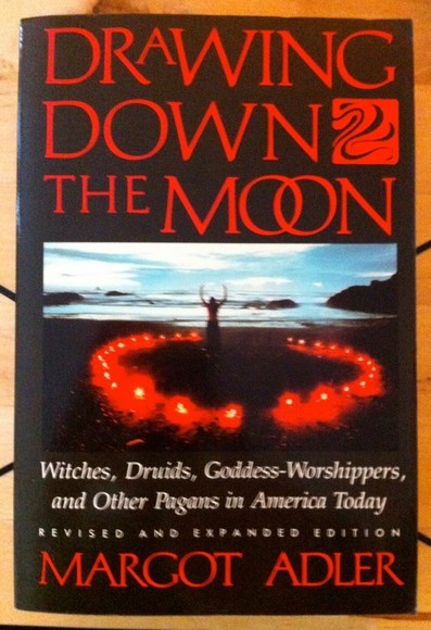 A black book cover. In the center is an image of a person by the ocean, arms raised, surrounded by a circle of red candles.

The cover reads:
Drawing Down The Moon
Witches, Druids, Goddess-Worshippers and Other Pagans in America Today.
Revised and expanded edition
Margot Adler