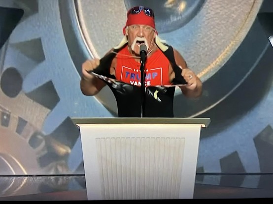 Hulk Hogan zerreißt sein Oberteil und man sieht ein Shirt auf dem Trump steht