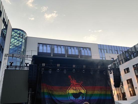 Große Regenbogenflagge mit Dudelsack an einer Bühne 