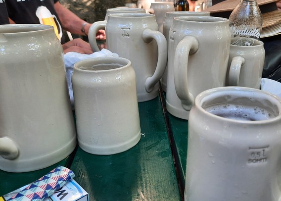 Stone beer mugs in 1l and 0.5l on a green table