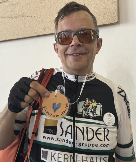 Verschwitzter Radfahrer (ich) mit einer gebastelten Medaille „Sieger der Herzen“. Gebastelt von der Kita Laubach.