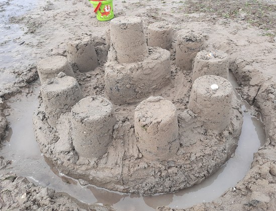 Eine Sandburg mit Burggraben voller Wasser