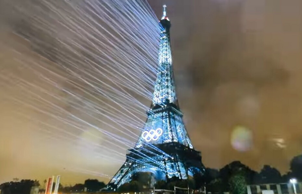 Eiffel Tower, bursting with blue illumination for the Olympics.