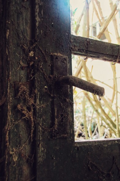 old door handle with rests of spiderwebs