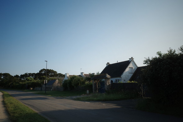 A road an a white house in the golden evening sun