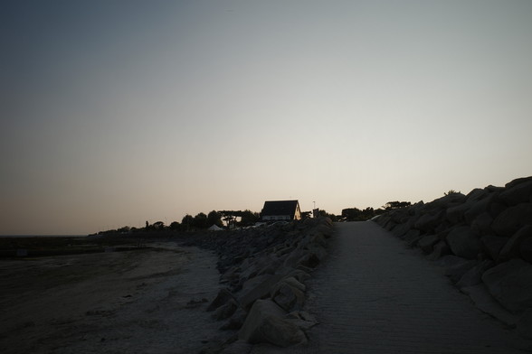 A building on a hill near the beach in the evening sun 