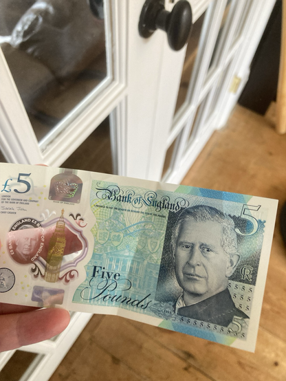 A £5 British bank note, with a drawing of King Charles where it used to be Queen Elizabeth and that’s weird because she was queen forever