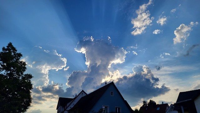 Abendhimmel mit bizarren Wolken, welche am Himmel Schatten werfen.