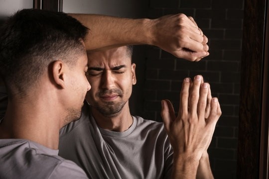 stonk image of a generic sad man facing a mirror.