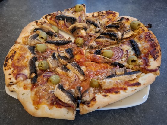 Selbstgemachte Pizza mit Champignons und Oliven.