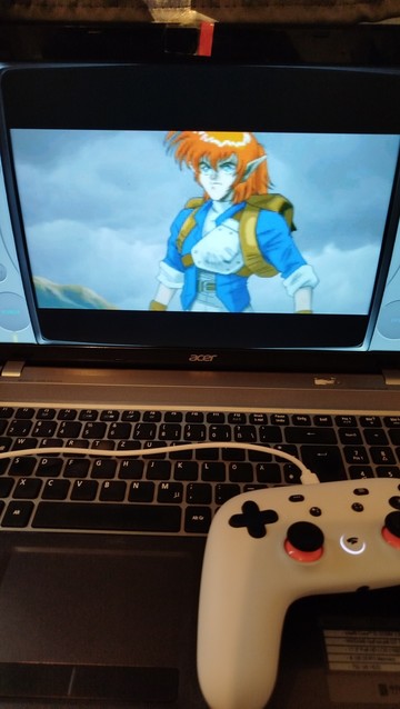 Ein Bild von meinem Laptop auf dem ein weißer Controller liegt. Darauf Läuft das Playstation 1 Spiel Alundra. Es ist aus dem Intro das ein anime ist und einen orage haarigen Knappe zeigen