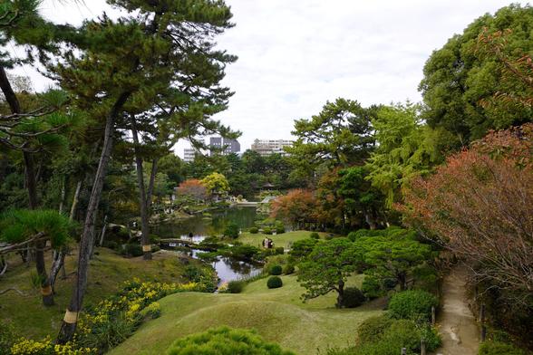 Blick über den Teich des Shukkei-en von einem Hügel zum Eingangsbereich