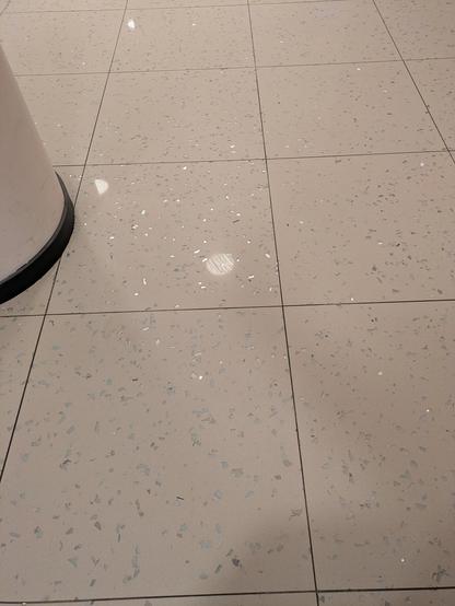 Heller Steinfußboden mit grauen und glitzernden Scherben eingesprenkelt.