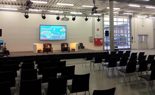 Bühne mit noch leeren Sitzen in Messehalle